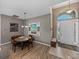 Open dining area with wood floors, a pendant light, and views of the front entryway at 4033 Phoenician Way, Winter Haven, FL 33884