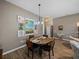 Cozy dining area featuring a round wood table, artwork, and wood-style flooring at 4033 Phoenician Way, Winter Haven, FL 33884