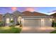 Charming single-story home with a well-manicured lawn, brick driveway, and a two-car garage at 4033 Phoenician Way, Winter Haven, FL 33884