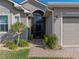 Charming home entrance with brick path, mature landscaping, and covered entryway at 4033 Phoenician Way, Winter Haven, FL 33884
