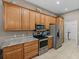Kitchen featuring stainless appliances, wood cabinets, and a grey countertop at 4033 Phoenician Way, Winter Haven, FL 33884