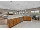 Open-concept kitchen featuring wood cabinets, granite counters, stainless appliances, and breakfast bar seating at 4033 Phoenician Way, Winter Haven, FL 33884