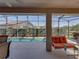Relaxing covered lanai with an outdoor couch and serene views of the pool and the backyard at 4033 Phoenician Way, Winter Haven, FL 33884