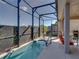 Tranquil screened-in pool with a hot tub and patio seating, perfect for relaxation at 4033 Phoenician Way, Winter Haven, FL 33884