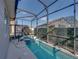 Screened-in pool area with a long pool, hot tub, and landscaped perimeter at 4033 Phoenician Way, Winter Haven, FL 33884