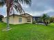 Charming backyard featuring lush green grass, mature palm trees, and a screened-in lanai at 4152 Limerick Dr, Lake Wales, FL 33859