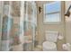 Toilet with a themed shower curtain and small window letting in natural light at 428 Lake Suzanne Dr, Lake Wales, FL 33859