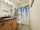 Bathroom with leafy shower curtain, floral decorations, and sink with dark countertop at 4540 Turnberry Ln, Lake Wales, FL 33859