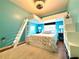 Bedroom with loft bed, ladder, display shelves and bright blue walls at 4540 Turnberry Ln, Lake Wales, FL 33859