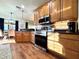 The kitchen features stainless steel appliances, wooden cabinets, granite countertops, and an adjoining dining area at 4540 Turnberry Ln, Lake Wales, FL 33859