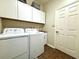 Bright laundry room area with a washer, a dryer, white cabinets, and a tile floor at 4540 Turnberry Ln, Lake Wales, FL 33859