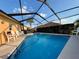 Beautiful screened-in pool area with deck chairs, palm trees, and clear blue water at 4540 Turnberry Ln, Lake Wales, FL 33859