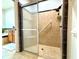 Shower featuring accessible design, neutral tile, and glass sliding door at 4540 Turnberry Ln, Lake Wales, FL 33859