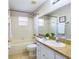 Well-lit bathroom with a bathtub-shower, single sink vanity, and classic tile flooring, perfect for a clean aesthetic at 4639 Great Blue Heron Dr, Lakeland, FL 33812