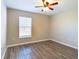 A simple, yet stylish bedroom featuring hard wood floors and a window that offers natural light at 4639 Great Blue Heron Dr, Lakeland, FL 33812
