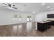 Open-concept living room featuring wood floors, ceiling fan, and plenty of natural light at 4924 Saint James St, Winter Haven, FL 33881