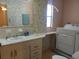 Bathroom with a sink, a laundry area, and a window for natural light at 6059 Southern Oaks Se Dr, Winter Haven, FL 33884
