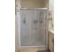 The bathroom is equipped with frosted sliding shower doors, complementing the tile flooring and wall design at 6059 Southern Oaks Se Dr, Winter Haven, FL 33884