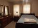 Comfortable bedroom featuring a wooden bed frame and coordinating dresser and nightstand at 6059 Southern Oaks Se Dr, Winter Haven, FL 33884
