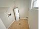 Utility room with water heater and hookups, plus shelving for storage at 618 Chester Dr, Lakeland, FL 33803