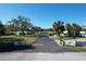Inviting entrance to a well-kept community featuring lush landscaping, mature trees, and attractive single-story homes at 720 Fonda Ct # 54, Lakeland, FL 33803