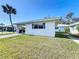 Charming single-story home with a carport, white exterior, gray shutters, and a well-manicured lawn under a clear blue sky at 720 Fonda Ct # 54, Lakeland, FL 33803