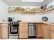 Efficient kitchen featuring butcher block countertops, open shelves, and stainless steel dishwasher at 720 Fonda Ct # 54, Lakeland, FL 33803