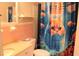 Cute bathroom featuring a cat shower curtain, pink tile walls, and white fixtures at 807 S 1St St, Lake Wales, FL 33853