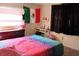 Cozy bedroom featuring colorful bedding, neutral walls, and a Mexican flag above the bed at 807 S 1St St, Lake Wales, FL 33853