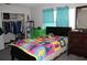 This bedroom features a closet, colorful bedding, neutral walls, and ample natural light at 807 S 1St St, Lake Wales, FL 33853
