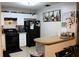 Classic kitchen with white cabinets, black appliances, brick accent on breakfast bar and tiled floor at 807 S 1St St, Lake Wales, FL 33853