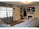 The cozy living room boasts a faux fireplace, a mounted TV, and natural light from the checkered-curtained window at 807 S 1St St, Lake Wales, FL 33853