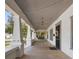Inviting front porch with wood floors, decorative columns, overhead lighting, and a charming porch swing at 907 Vistabula St, Lakeland, FL 33801