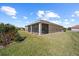 Home's landscaped backyard featuring a screened-in lanai and lush green grass at 1017 Sawgrass Dr, Winter Haven, FL 33884