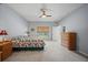 Bright bedroom featuring neutral carpet, ceiling fan and large window at 1017 Sawgrass Dr, Winter Haven, FL 33884