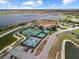 Aerial shot of active pickleball and tennis courts in a community with scenic water views and manicured landscaping at 1017 Sawgrass Dr, Winter Haven, FL 33884