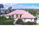 Aerial view of a single-Gathering home with a red tile roof, manicured lawn, and arched entryway at 105 Wyndham Dr, Winter Haven, FL 33884