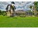 Expansive backyard with screened-in pool area and lush lawn at 105 Wyndham Dr, Winter Haven, FL 33884