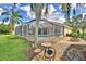 Outdoor seating area and fire pit in the backyard featuring a screened-in pool at 105 Wyndham Dr, Winter Haven, FL 33884