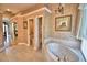 Bathroom featuring a soaking tub and dual sinks and archway in distance at 105 Wyndham Dr, Winter Haven, FL 33884
