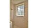 Tiled shower stall featuring a glass block window, and gold fixtures at 105 Wyndham Dr, Winter Haven, FL 33884