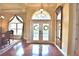 Elegant foyer with double glass doors, wood floors, a decorative mirror and chandelier lighting at 105 Wyndham Dr, Winter Haven, FL 33884