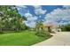 Property view with manicured lawn and landscaping, complemented by palm trees and a terracotta roof at 105 Wyndham Dr, Winter Haven, FL 33884