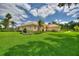 A beautifully maintained property with lush green lawn, vibrant landscaping, and a terracotta-tiled roof at 105 Wyndham Dr, Winter Haven, FL 33884