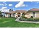 Attractive home with arched entryway, double doors, beautiful landscaping, and well-maintained lawn at 105 Wyndham Dr, Winter Haven, FL 33884