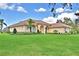Charming single-story home featuring a red tile roof, manicured lawn, and arched entryway at 105 Wyndham Dr, Winter Haven, FL 33884