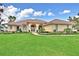 Charming single-story home featuring a red tile roof, manicured lawn, and arched entryway at 105 Wyndham Dr, Winter Haven, FL 33884
