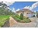 Exterior view of a single-Gathering home with a manicured lawn, arched entryway, and attached garage at 105 Wyndham Dr, Winter Haven, FL 33884