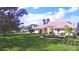 Exterior view of a single-Gathering home with a manicured lawn, arched entryway, and lush landscaping at 105 Wyndham Dr, Winter Haven, FL 33884