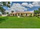 Inviting single-story home featuring a well-manicured lawn, vibrant landscaping, and a terracotta-tiled roof at 105 Wyndham Dr, Winter Haven, FL 33884